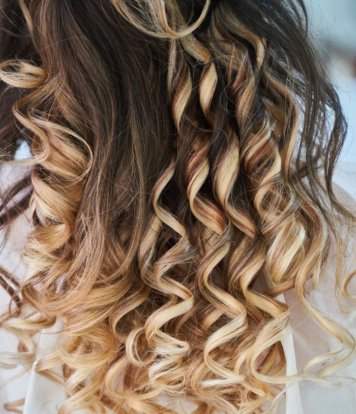 Long curly hair with honey balayage highlights