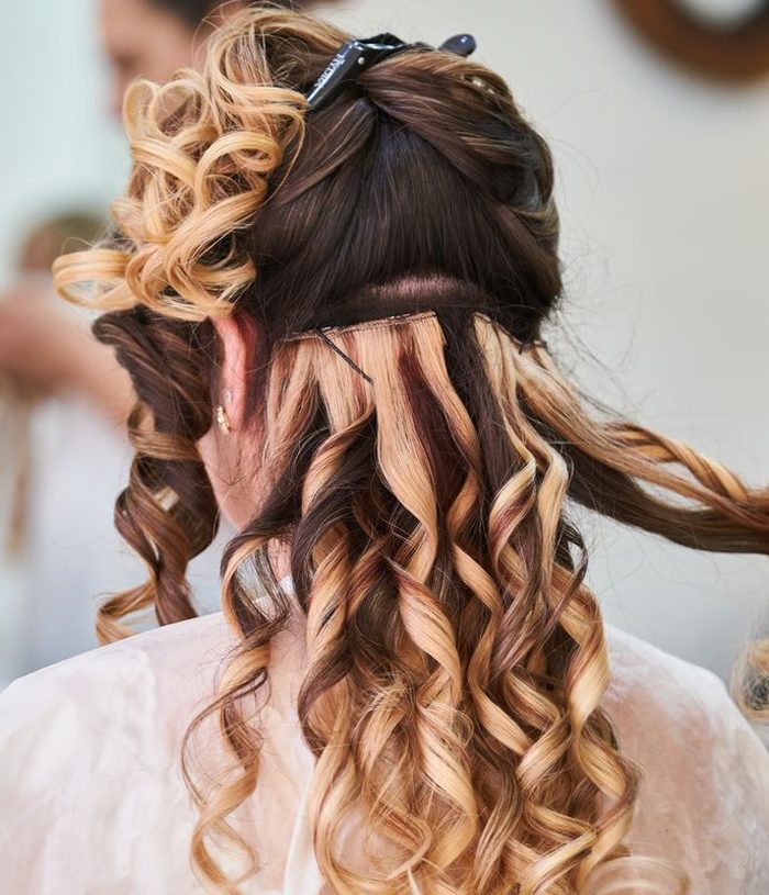 Bridal hair being pinned into a curled half-up set
